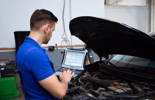 young-confident-handsome-car-mechanic-with-laptop-hand-conducts-computer-diagnostics-errors-car-systems